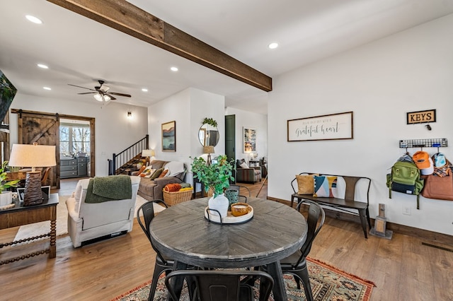 dining space with stairway, wood finished floors, beam ceiling, recessed lighting, and a barn door