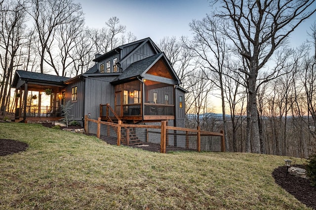 back of property with a lawn and roof with shingles