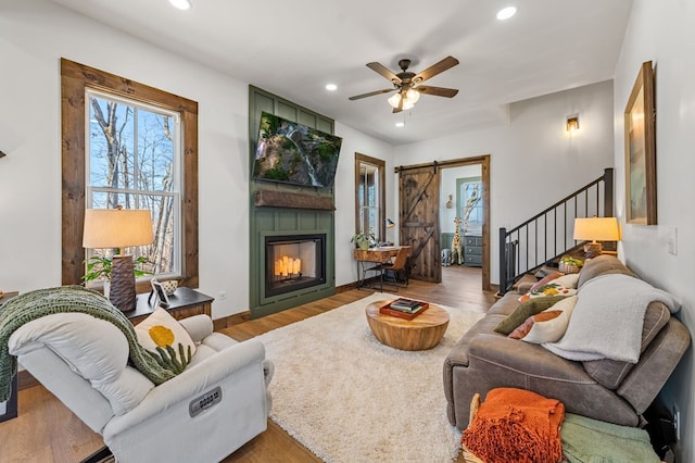 living room featuring recessed lighting, a barn door, plenty of natural light, and wood finished floors