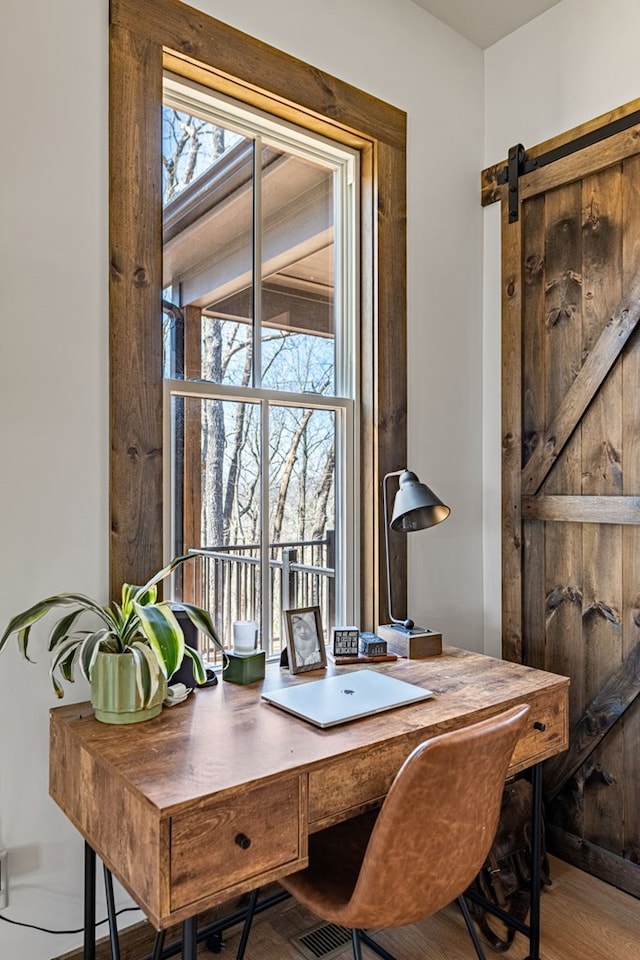 office area with a barn door and wood finished floors