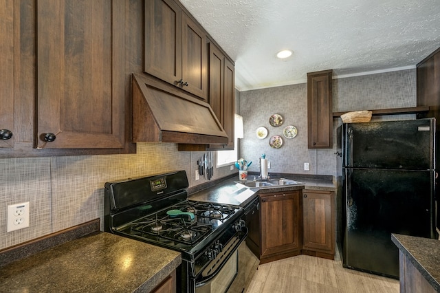 kitchen with sink, dark brown cabinetry, black appliances, a textured ceiling, and custom exhaust hood