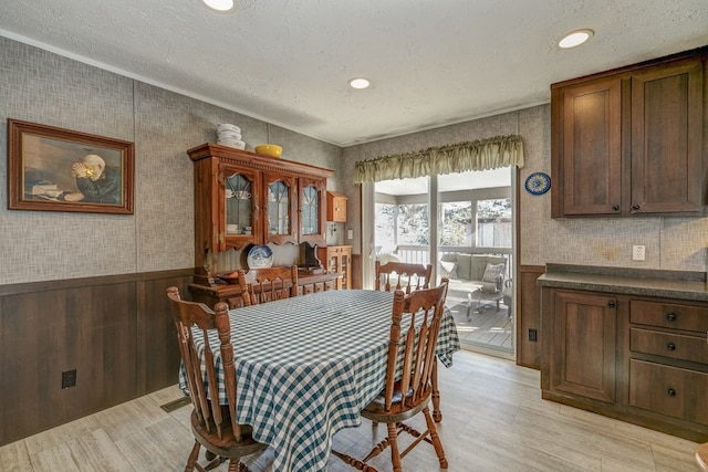 dining room with light hardwood / wood-style floors and a textured ceiling