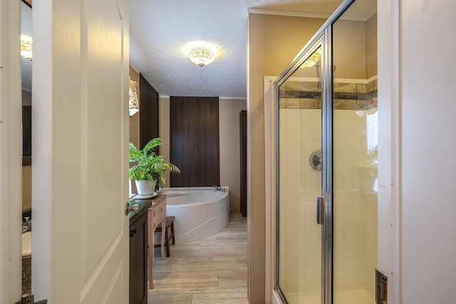 bathroom featuring plus walk in shower, vanity, and a textured ceiling