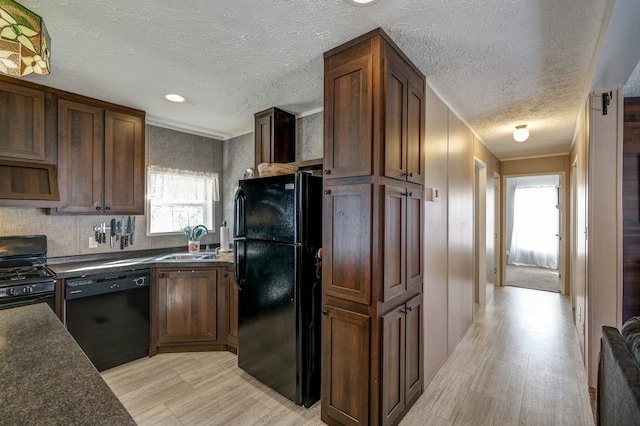 kitchen featuring sink, tasteful backsplash, a textured ceiling, light hardwood / wood-style flooring, and black appliances