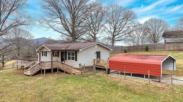 rear view of property with a carport, a yard, and a mountain view