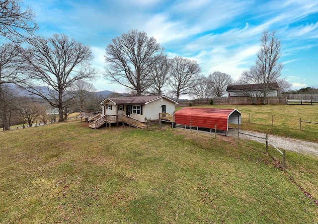 exterior space featuring a wooden deck, a rural view, and a front lawn