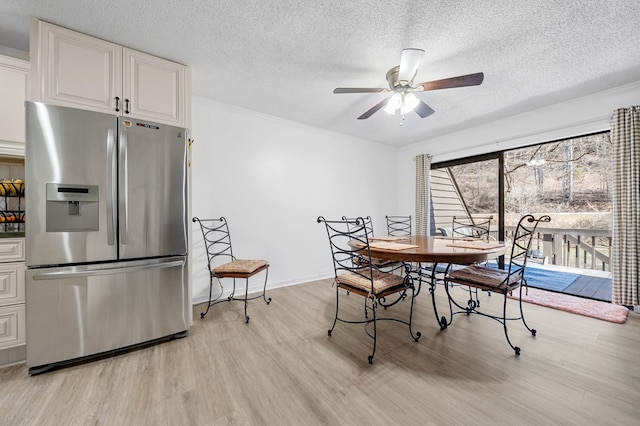 dining area with baseboards, ceiling fan, a textured ceiling, and light wood-style floors