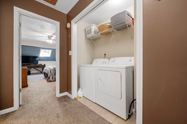 washroom featuring light carpet, washer and clothes dryer, a textured ceiling, light tile patterned floors, and laundry area