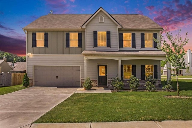 view of front of house with a front yard, fence, an attached garage, concrete driveway, and board and batten siding