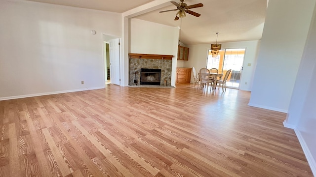 unfurnished living room with a fireplace, ceiling fan, light hardwood / wood-style floors, and lofted ceiling