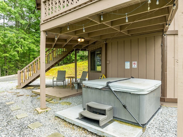 view of patio / terrace with a deck, stairway, and a hot tub