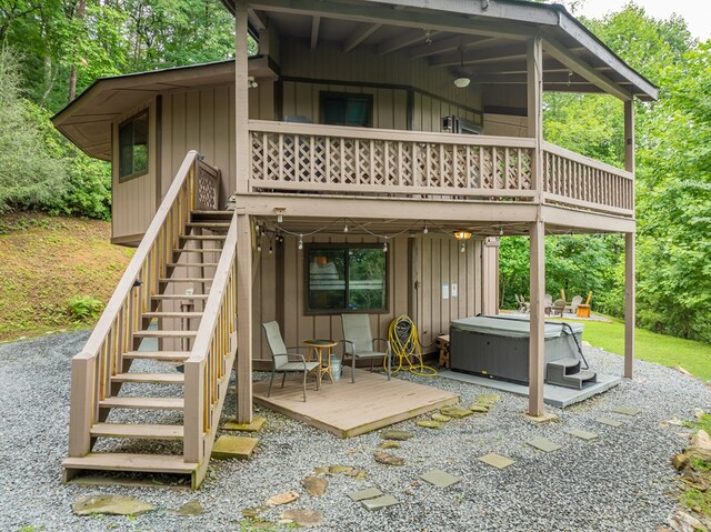 back of property featuring a patio, a hot tub, and a wooden deck