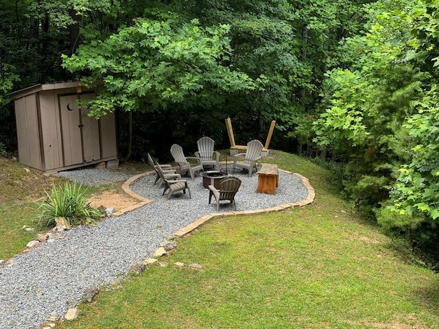 view of yard with a storage shed, an outdoor structure, a patio, and an outdoor fire pit