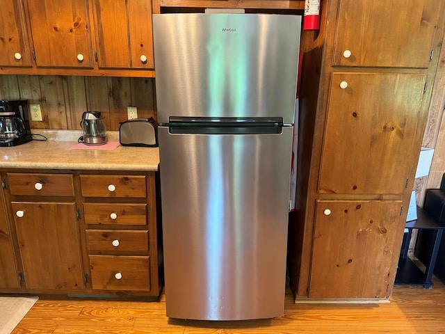 kitchen with stainless steel fridge and light hardwood / wood-style flooring