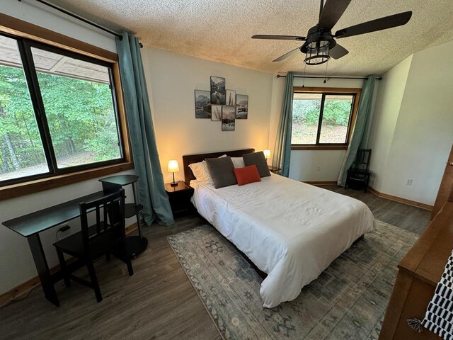 bedroom with dark hardwood / wood-style flooring, a textured ceiling, and ceiling fan