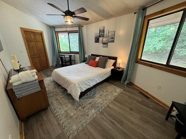 bedroom with a textured ceiling, dark wood-type flooring, ceiling fan, vaulted ceiling, and a closet