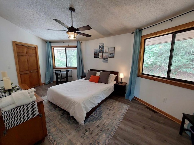 bedroom featuring visible vents, ceiling fan, vaulted ceiling, wood finished floors, and a textured ceiling