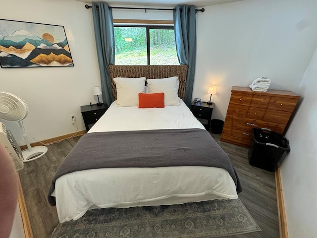 bedroom with dark wood finished floors and baseboards