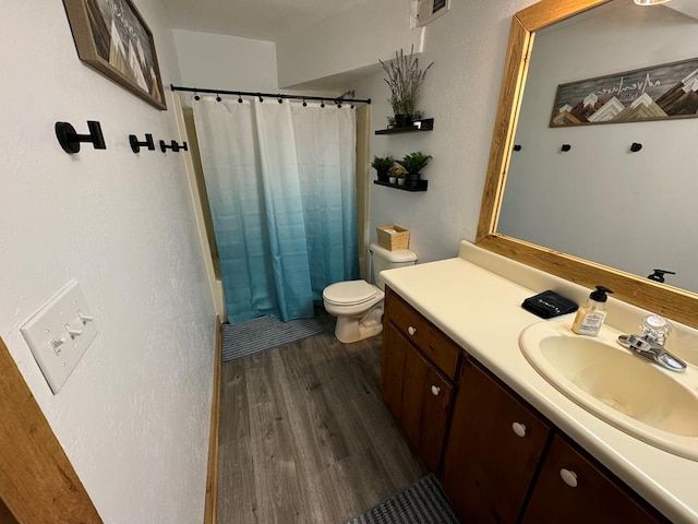 bathroom featuring vanity, a shower with shower curtain, toilet, and wood finished floors