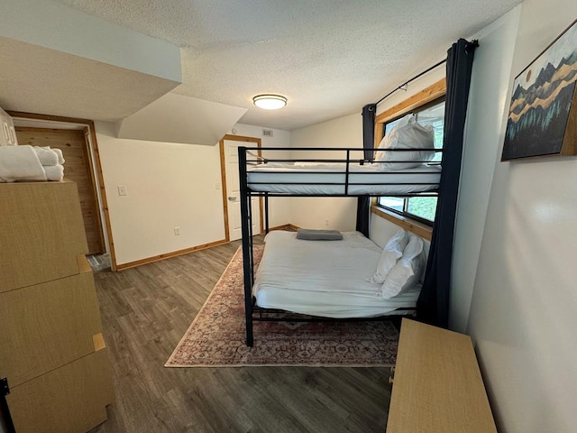 bedroom with a textured ceiling and wood-type flooring