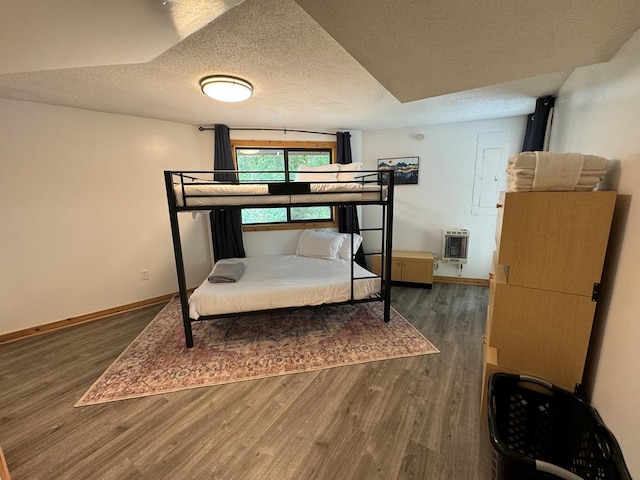 bedroom with dark hardwood / wood-style floors and a textured ceiling