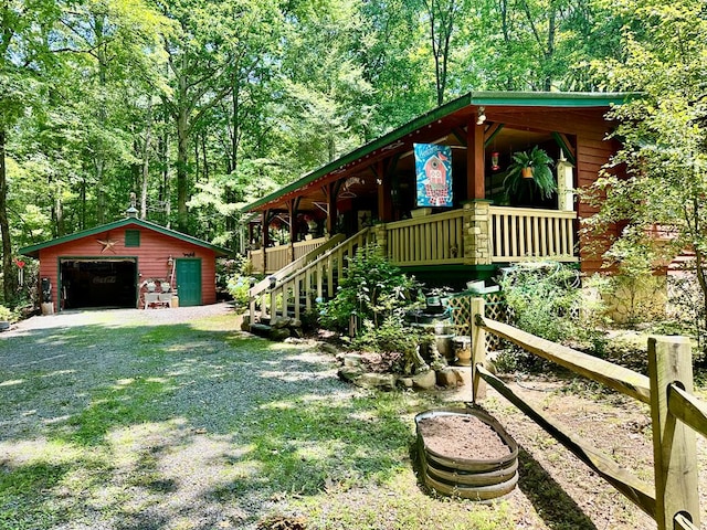 10 Whippoorwill Ln, Murphy, NC 28906 - view of front of house with a detached garage, an outdoor structure, a porch, driveway, and a wooded view