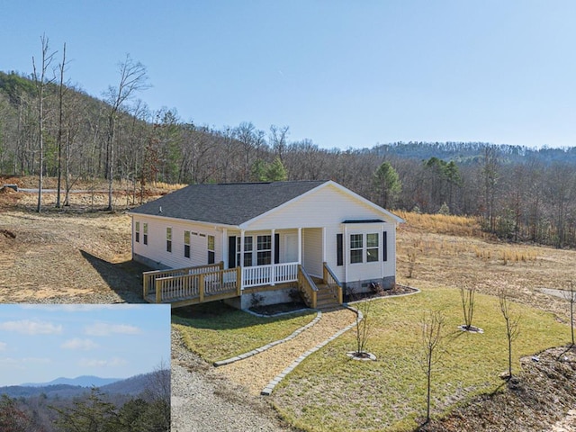 view of front of house with a front yard and a deck with mountain view