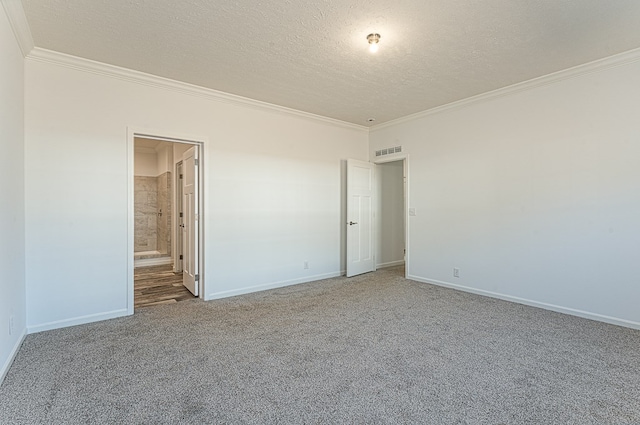 spare room featuring ornamental molding, carpet floors, and a textured ceiling