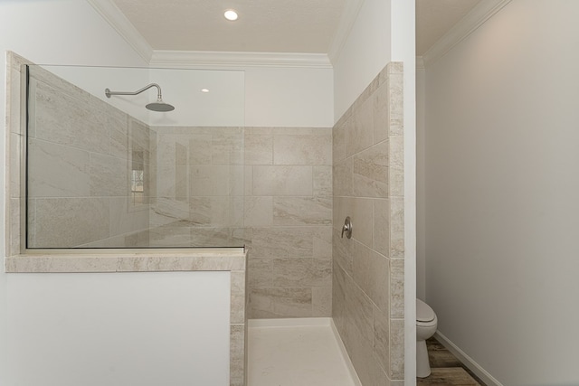 bathroom featuring crown molding, tiled shower, and toilet