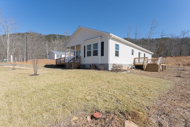 view of property exterior with a wooden deck and a yard