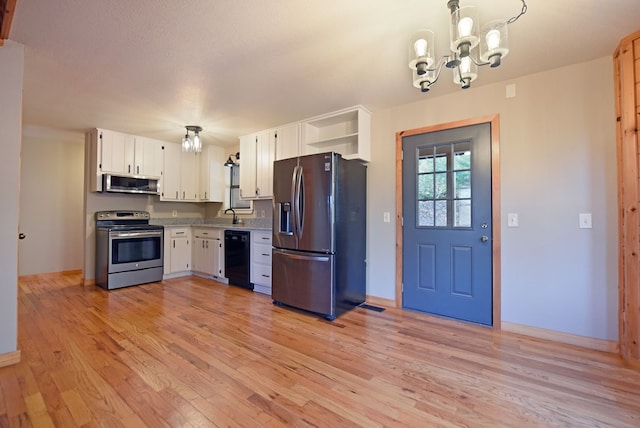 kitchen featuring appliances with stainless steel finishes, white cabinets, hanging light fixtures, a notable chandelier, and light hardwood / wood-style flooring