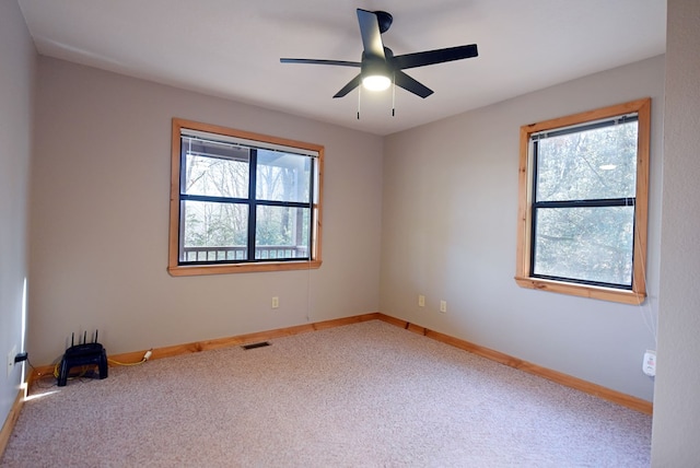 empty room featuring ceiling fan and carpet