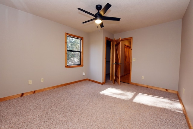 spare room with light colored carpet and ceiling fan