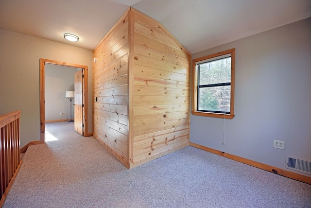 hall with vaulted ceiling and light carpet