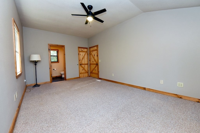 carpeted spare room with vaulted ceiling and ceiling fan