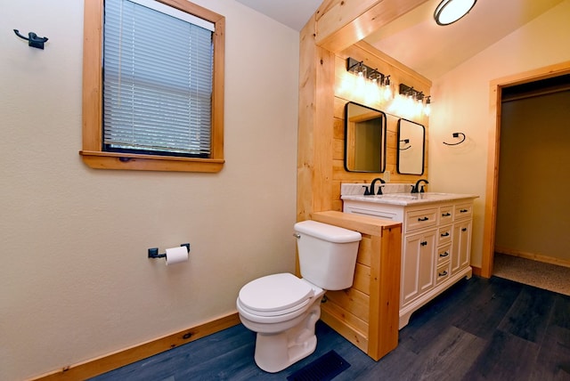 bathroom featuring vanity, lofted ceiling, hardwood / wood-style floors, and toilet