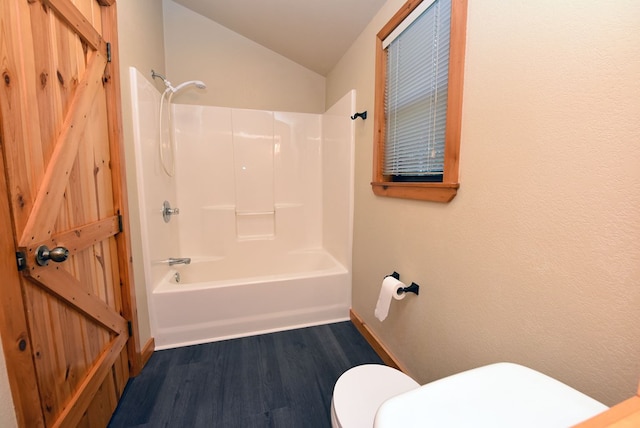 bathroom featuring bathtub / shower combination, lofted ceiling, toilet, and hardwood / wood-style floors