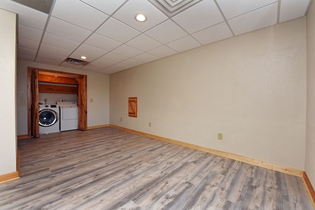 spare room featuring washer and clothes dryer, wood-type flooring, and a paneled ceiling