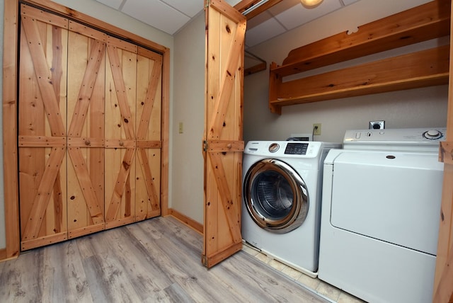 laundry area with independent washer and dryer and light hardwood / wood-style flooring