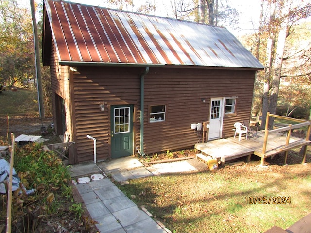 rear view of house featuring a wooden deck