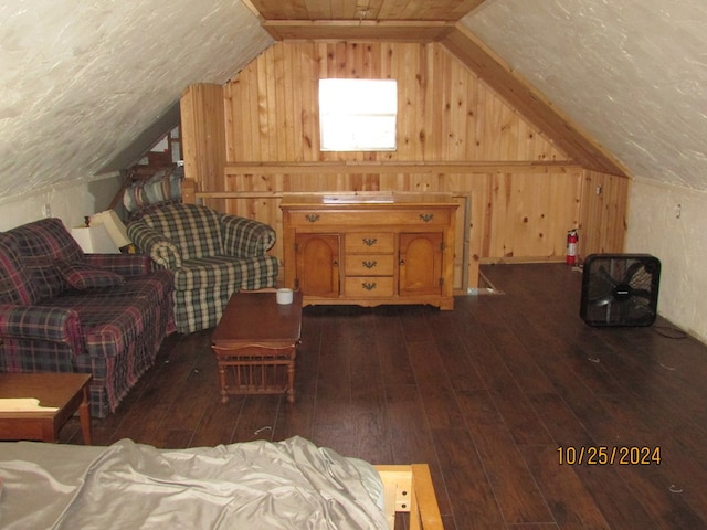 interior space featuring lofted ceiling, dark wood-type flooring, and wooden walls