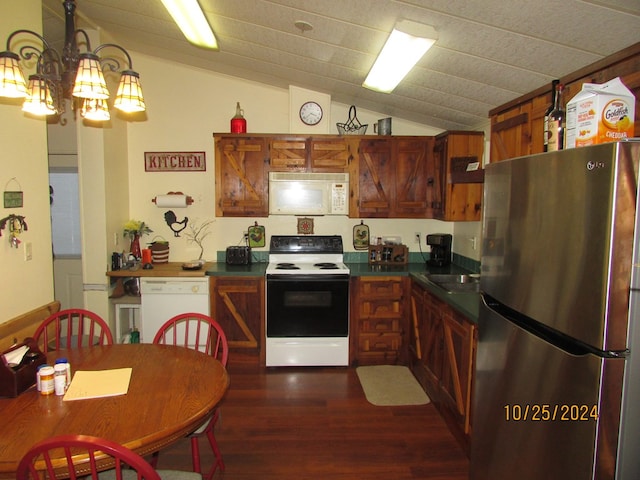 kitchen featuring lofted ceiling, hanging light fixtures, a chandelier, dark hardwood / wood-style floors, and white appliances