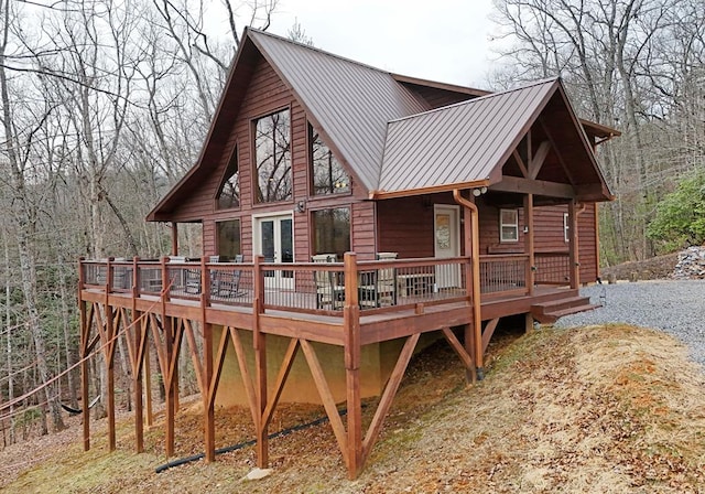 back of house with metal roof and a wooden deck