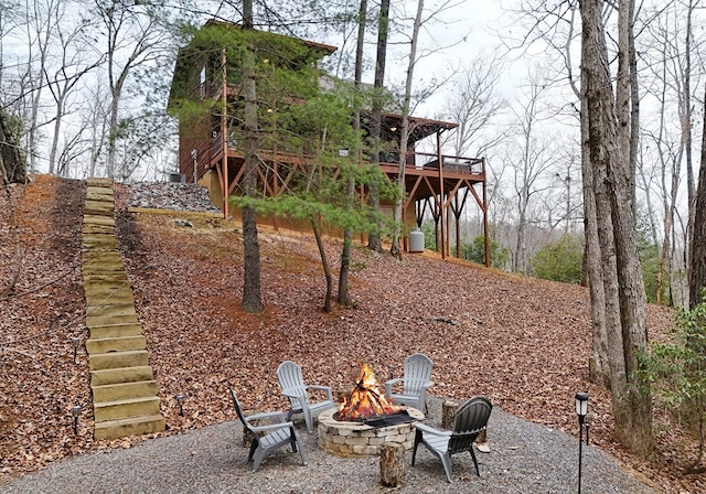 view of yard with a patio area, a fire pit, a wooden deck, and stairs