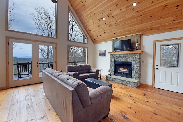 living area with a stone fireplace, french doors, wooden ceiling, and hardwood / wood-style flooring