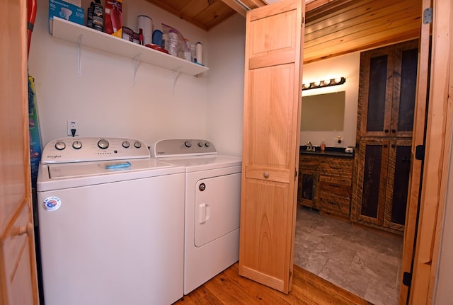 laundry area with light wood-style floors, washer and dryer, laundry area, and wooden ceiling