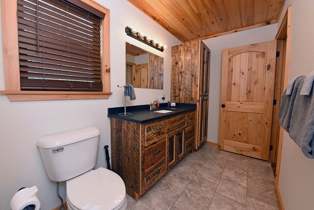 bathroom with baseboards, toilet, wooden ceiling, tile patterned floors, and vanity