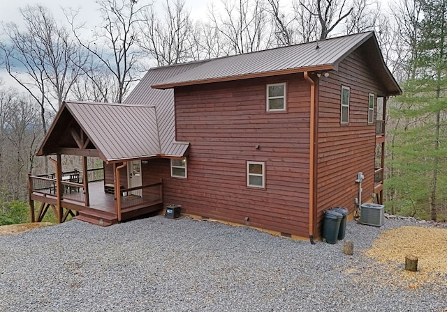 view of property exterior featuring a deck, metal roof, crawl space, and central air condition unit