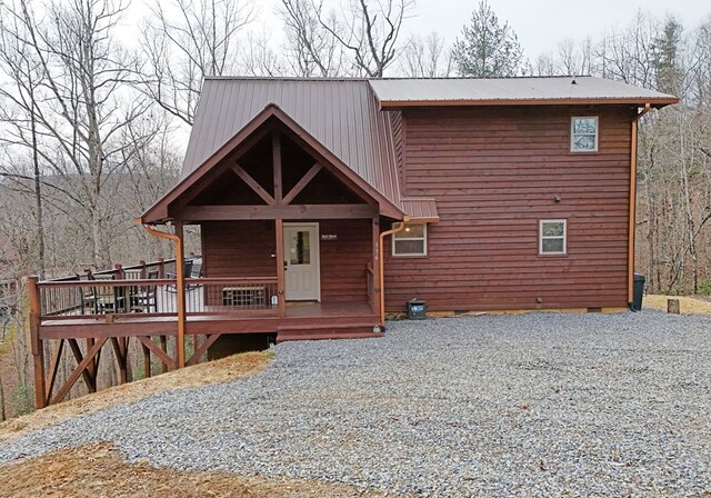 chalet / cabin with gravel driveway, metal roof, and crawl space