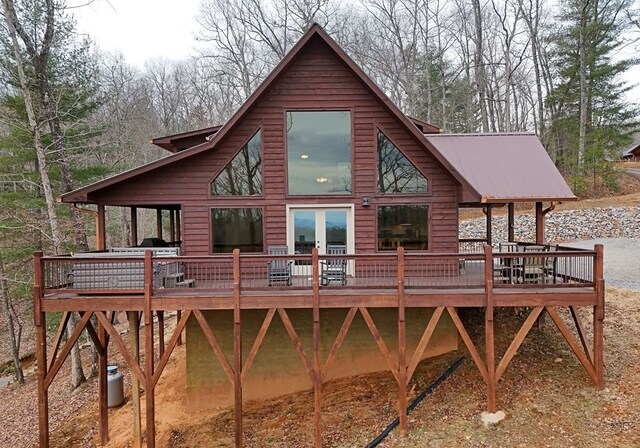 back of house featuring metal roof and a deck